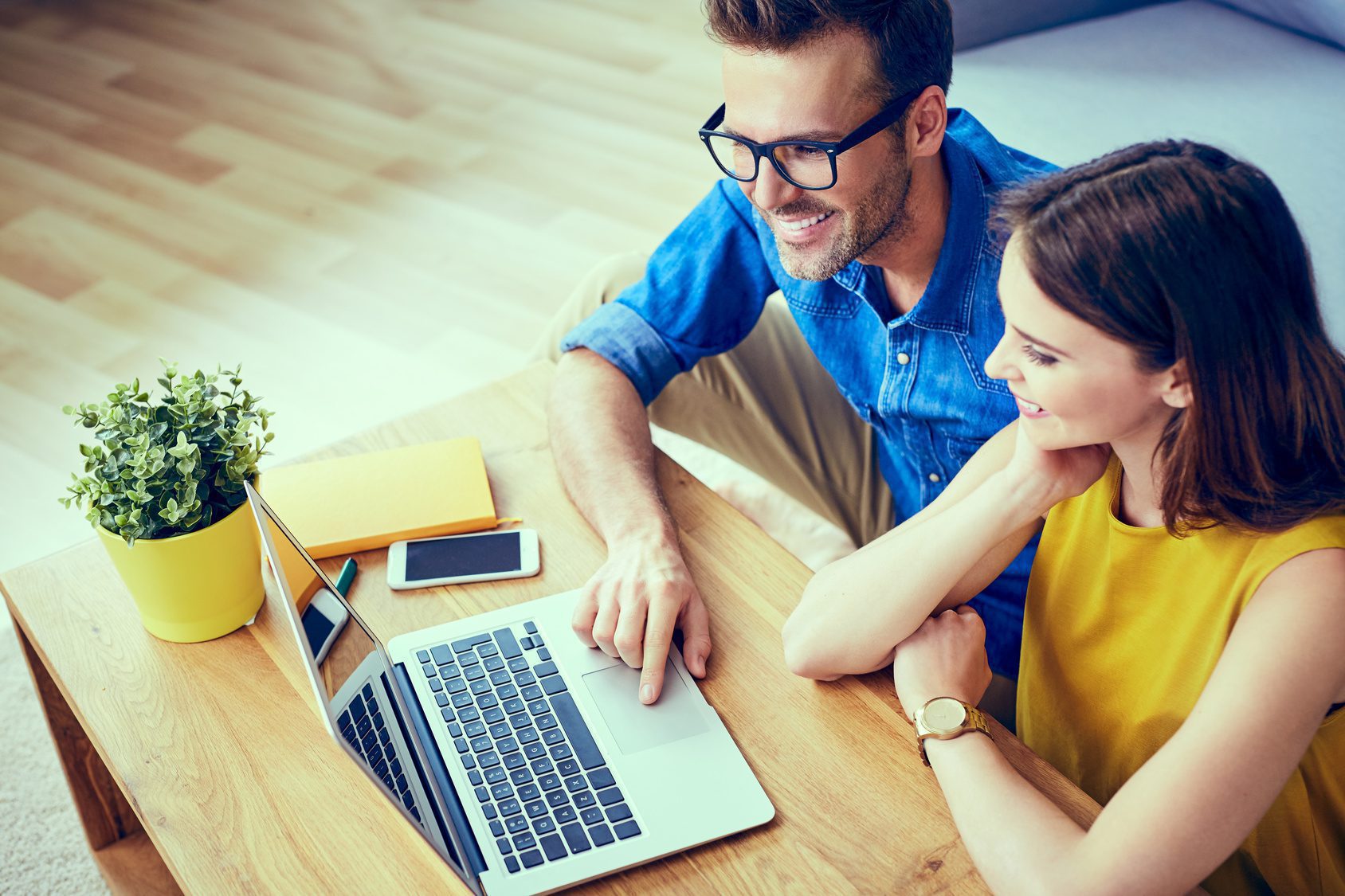 Couple at home doing online shopping with laptop