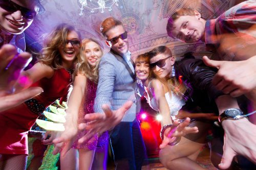 Group of young people having fun dancing at party.