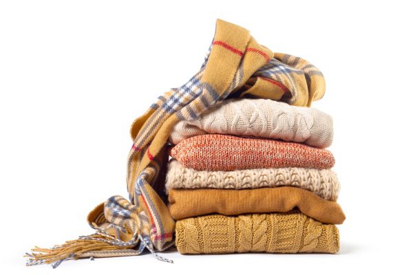 Stack of various sweaters isolated on white background