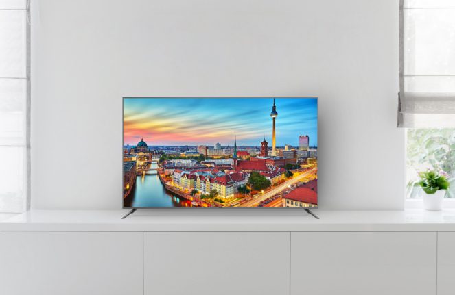 white living room detail tv on wall with commode and epoxy flooring