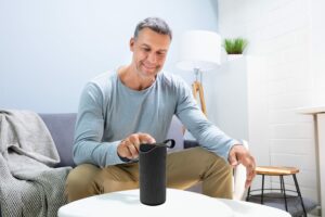 Man Pressing Button On Wireless Speaker