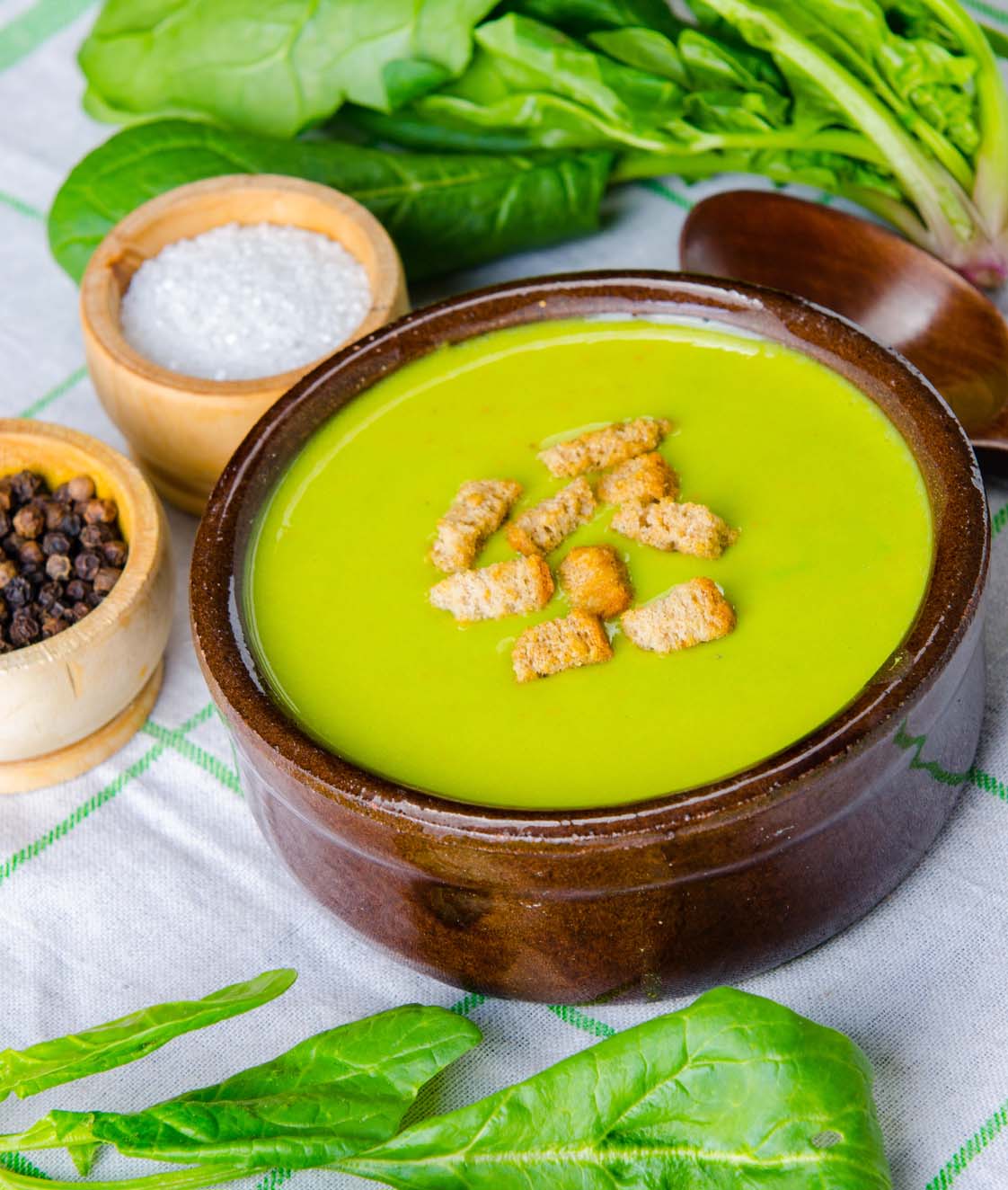 Spinach soup served on wooden board